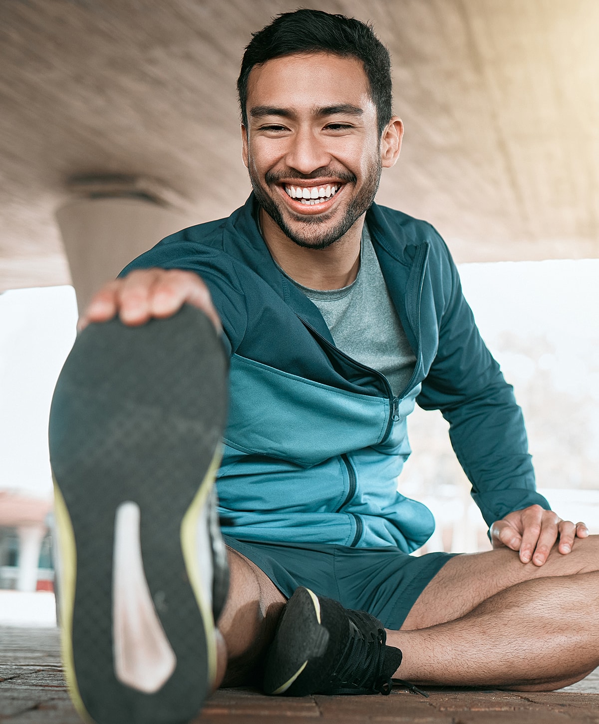 Smiling man stretching outdoors in athletic wear