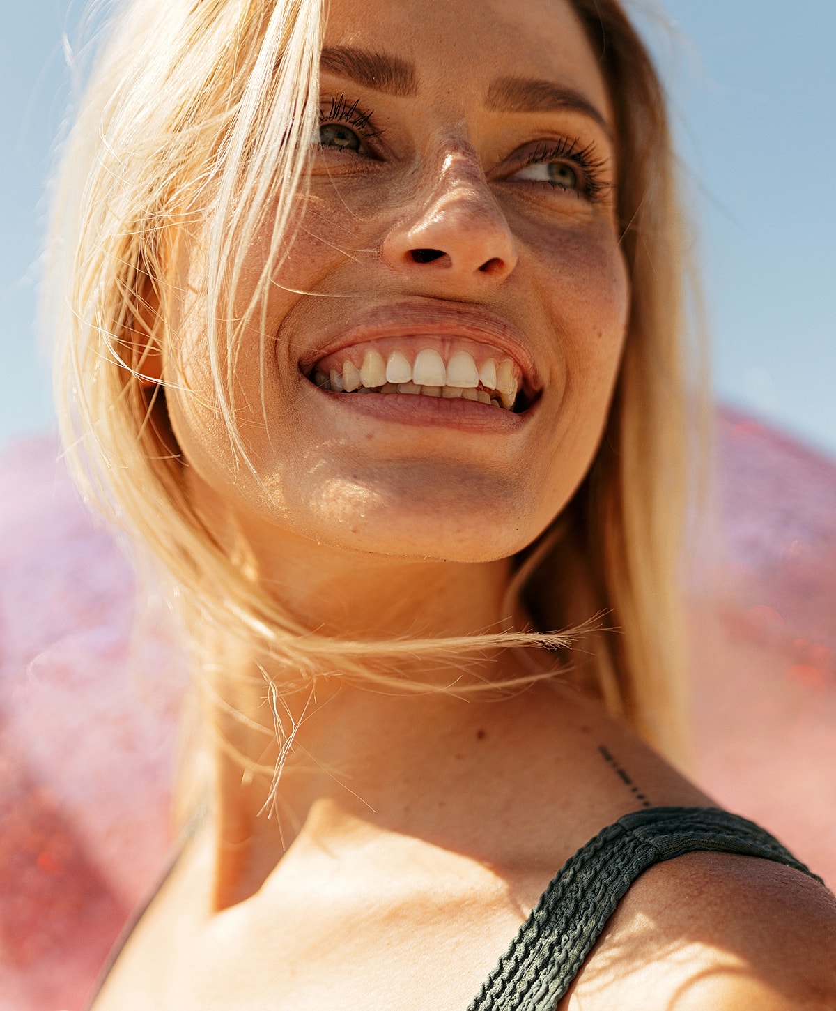 Smiling woman with blonde hair outdoors.