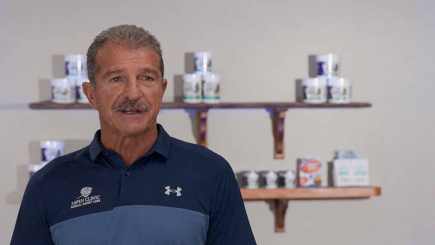 Man speaking in front of product display.